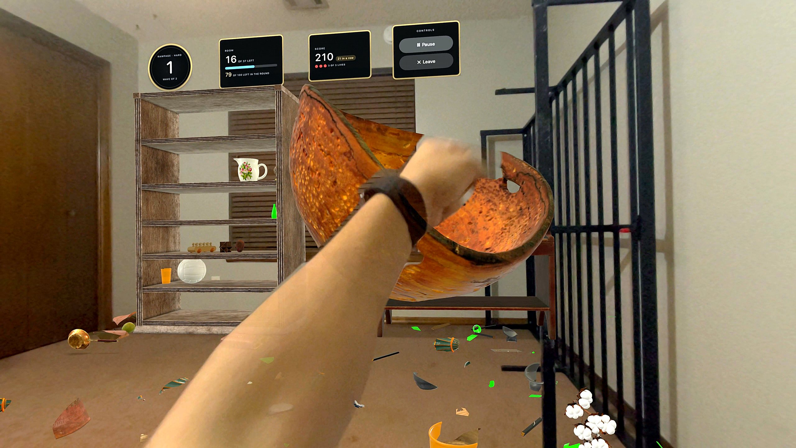 Playing Shatter Punch in a real home: a fist splits an orange bowl, our shelf stands among the furniture, and the score hangs on the wall in frames
